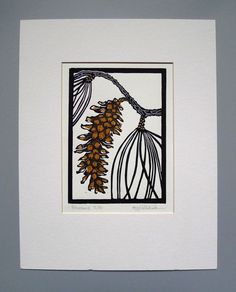 an image of a pinecone on a branch in a white frame hanging on the wall