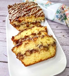 two slices of banana bread on a white plate with chocolate drizzled on top