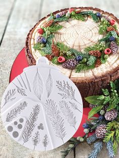 a cake decorated with pine cones and evergreen leaves