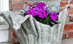 some purple flowers are in a cement planter