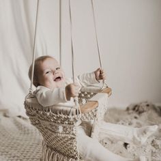 a baby is sitting in a hanging chair