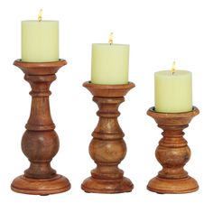 three wooden candlesticks with lit candles in them