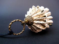 a keychain made out of old newspaper with a ring on the end that is attached to it