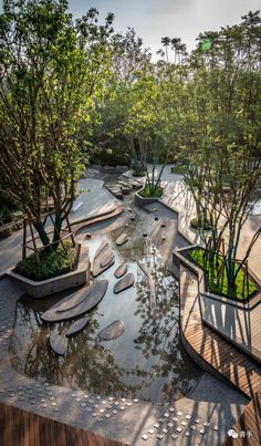 an outdoor garden with trees and plants in the center, surrounded by wooden walkways