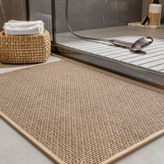 a close up of a bathroom rug on the ground near a shower door with a spoon and towel