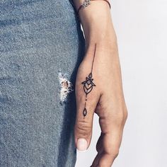 a woman's hand with a small tattoo on her left wrist and an arrow in the middle