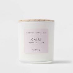 a white candle with a pink label that says calm lavender and sage on the front