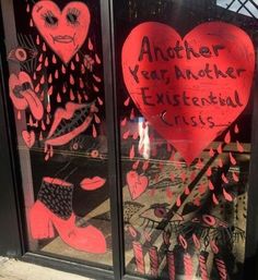 two glass windows with graffiti written on them and one has a red heart in the window