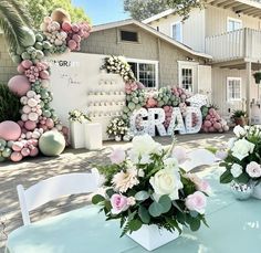 there is a table with flowers on it and balloons in the shape of letters that spell out rad