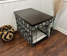 a wooden table sitting on top of a hard wood floor next to a basket filled with feathers