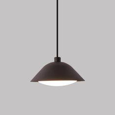 a light that is hanging from the ceiling in front of a gray wall and floor