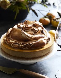 a cake sitting on top of a table next to wine glasses and utensils