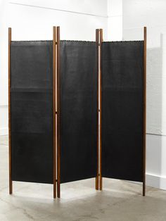 two black screens are standing next to each other in an empty room with white walls