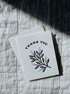 a thank you card sitting on top of a bed