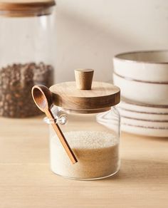 a wooden spoon sitting on top of a jar filled with sand