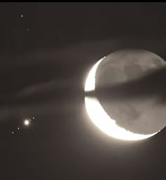 the moon is partially obscured by clouds as it passes in front of an earth - like object