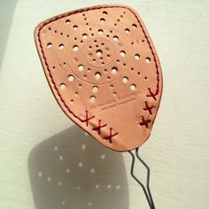 an ironing board with holes and red stitchs attached to the back of it