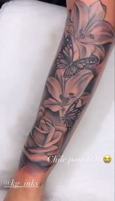 a woman's leg with flowers and butterflies on it