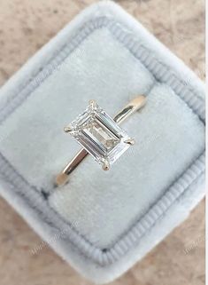 an engagement ring with a baguette cut diamond set in 18k yellow gold