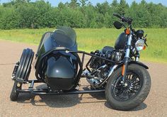 a motorcycle with a side car is parked on the road near some grass and trees