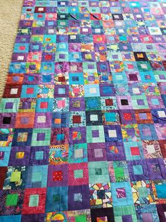 a colorful quilt is laying on the floor