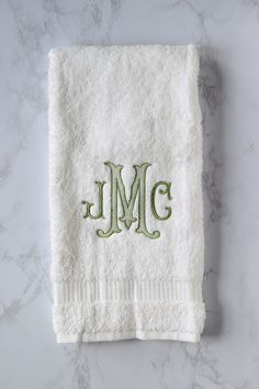 the monogrammed towel is on top of a marble counter with green trimming