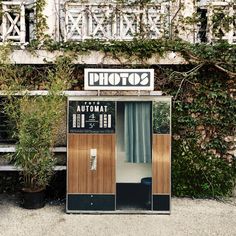 an old fashioned toilet sitting in front of a building with ivy growing on the walls