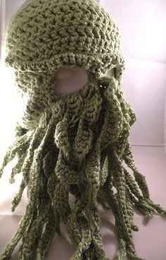 a crocheted hat with an octopus on the front and bottom, made from green yarn