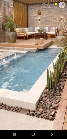 an outdoor swimming pool surrounded by rocks and plants