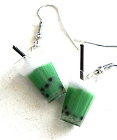 green and white earrings with black dots on them