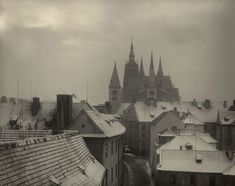 an old black and white photo of rooftops with snow on the roofs in europe