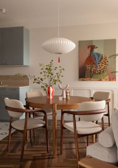 a dining room table surrounded by chairs and artwork