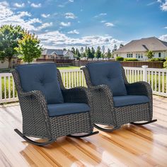 two wicker rocking chairs sitting on top of a wooden deck