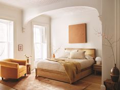 a bed sitting in a bedroom on top of a wooden floor next to a window