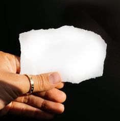 a person holding a piece of white paper in their hand