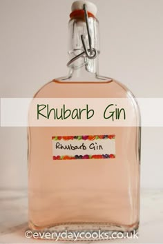 a bottle of rhubarb gin sitting on a table with the words rhubarb gin written in it