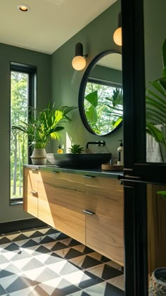 a bathroom with black and white checkered flooring next to a large round mirror