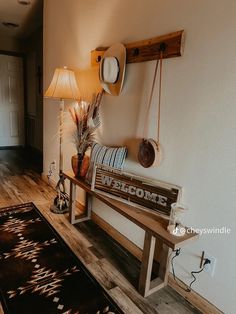 a wooden bench sitting in the middle of a room next to a lamp and rug