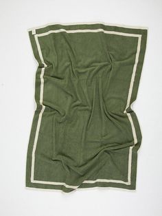 a green and white blanket laying on top of a table