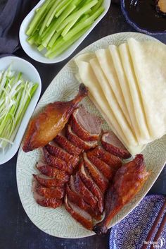 a plate with meat and vegetables on it next to bowls of sauces, rice and chopsticks