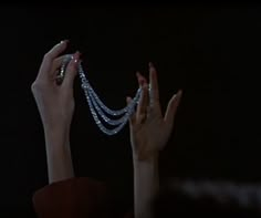 two hands reaching up to the sky with beads on them