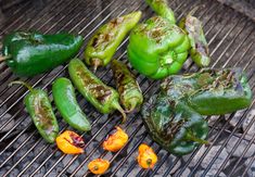 green peppers and yellow peppers are cooking on the grill