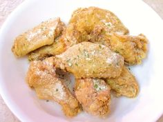 a white plate topped with fried food on top of a table