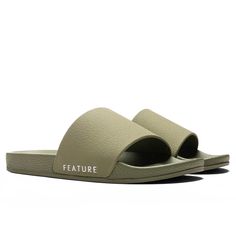 a pair of white slides with the word feature on it and an open toed sandal