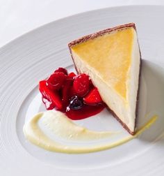 a slice of cheesecake with cherries on a white plate