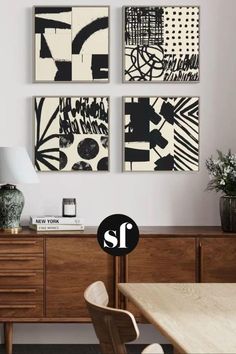 three black and white paintings hanging on the wall above a wooden dresser in a living room