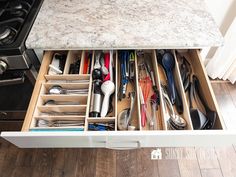 an open drawer with utensils in it