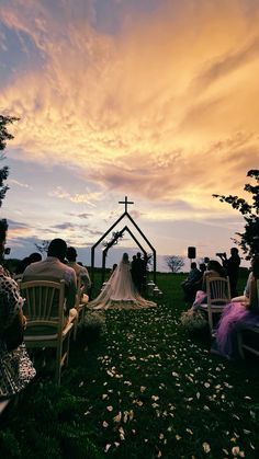 the bride and groom are sitting at their wedding ceremony in front of an outdoor chapel