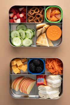 two metal trays filled with different types of food and snacks on top of each other