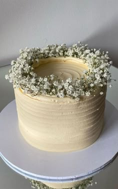 there is a cake with flowers on the top and bottom layer, sitting on a plate